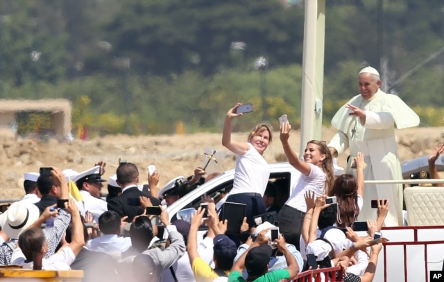 FILE - Pope Francis waves to the crowd as he rides in the popemobile through Samanes Park, where he will celebrate Mass, in Guayaquil, Ecuador, July 6, 2015.