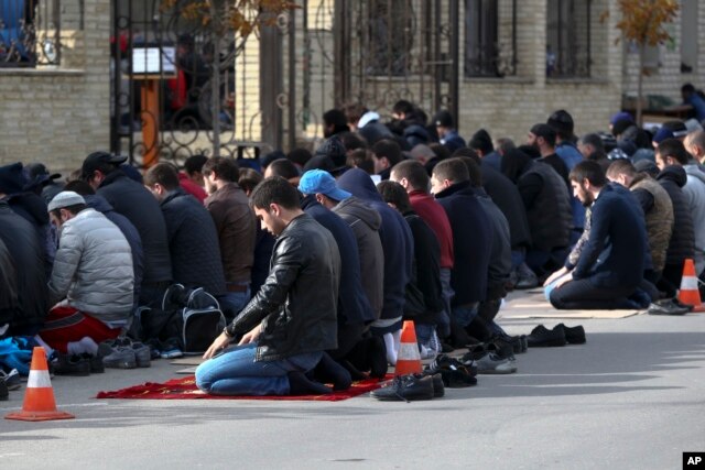 In this photo taken Friday, Nov. 13, 2015, men attend a Friday prayer at the mosque on Kotrova street in Dagestan's regional capital Makhachkala, Russia. An epidemic of recruitment for the Islamic State group has swept through the predominantly Muslim parts of Russia.