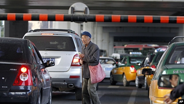 A Chinese beggar walks amongst traffic asking for a handout in Beijing, China. China's inflation rate edged lower in September, giving Chinese leaders leeway to stimulate the economy as U.S. and European growth slows, October 14, 2011.