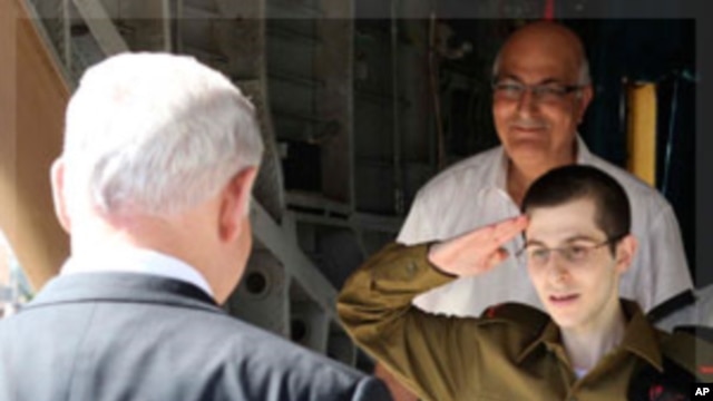 Gilad Shalit salutes in front of Israel's Prime Minister Netanyahu at Tel Nof air base, Oct 18, 2011