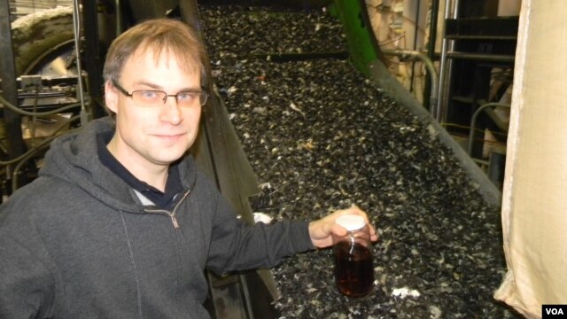 CEO John Bordynuik with a jar of fuel produced from waste plastic in JBI’s factory in Niagara Falls, New York. (VOA/D. Robison)                               