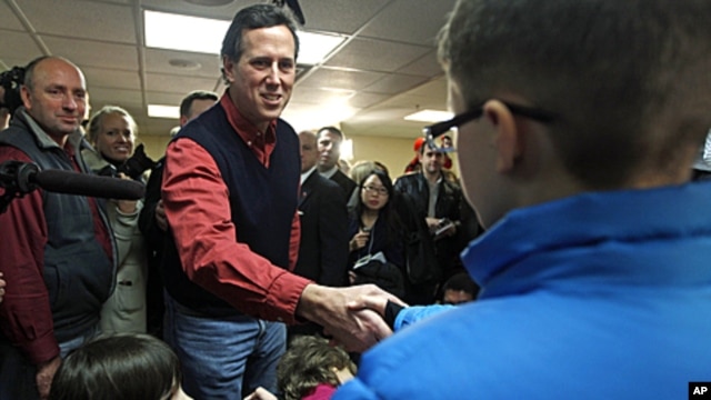 Republican presidential candidate former Pennsylvania Senator Rick Santorum reaches to greet children during a campaign stop in Brentwood, New Hampshire, January 4, 2012.