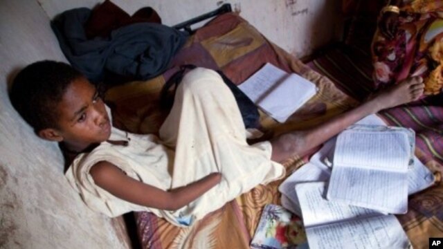 A handout picture released by the United Nations-African Union Mission in Darfur (UNAMID) shows Sudanese Abdulrahim Ahmed Mohammed, 12, sitting in his house at Al-Salam camp for internally displaced people in El-Fasher, the administrative capital of North