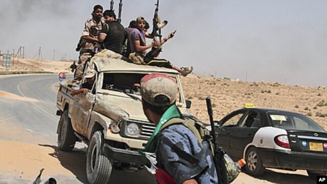 Libyan rebels on their way back from the front line after a six-hour battle in which they succeeded to liberate al-Qawalish, 100 kilometers (60 miles) southwest of Tripoli, July 6, 2011