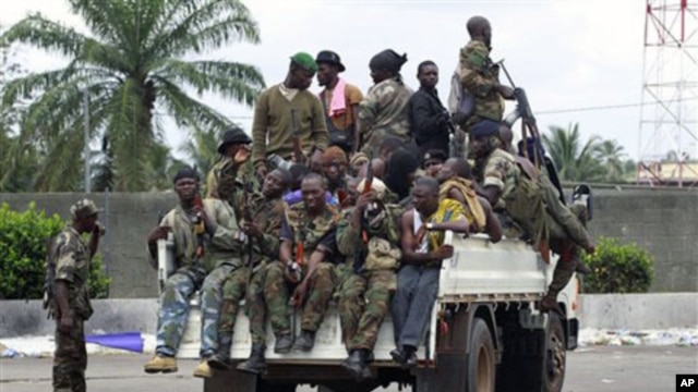 Soldiers loyal to Alassane Ouattara, along with several men who were detained for unknown reasons, drive past a checkpoint serving as an operating base, at one of the main entrances to Abidjan, Ivory Coast, April 7, 2011.