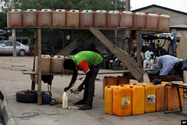 FILE - A man sells fuel on the road side in Kano, Nigeria, April 1, 2016. A fuel shortage in the country has created long lines at gas stations.