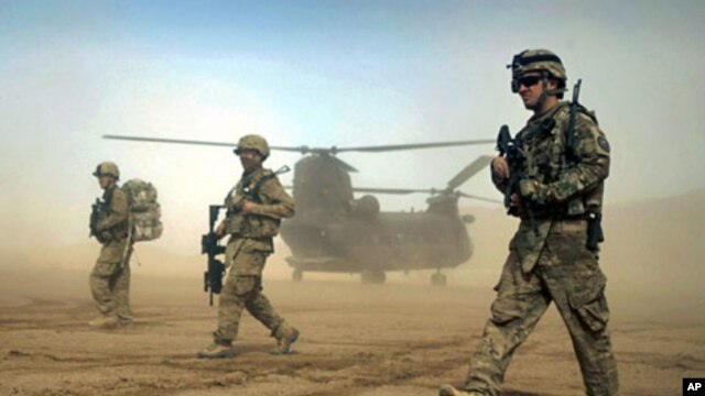 U.S. soldiers participating in the NATO- led International Security Assistance Force (ISAF) walk ahead of a Chinook helicopter near the place where the foundation of a hospital was laid in Shindand, Herat, west of Kabul, Afghanistan, January 28, 2012