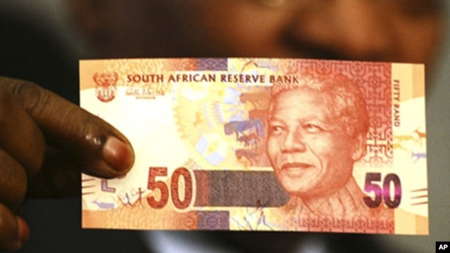 South Africa's President Jacob Zuma holds up a banknote bearing the face of former president Nelson Mandela in Pretoria February 11, 2012.
