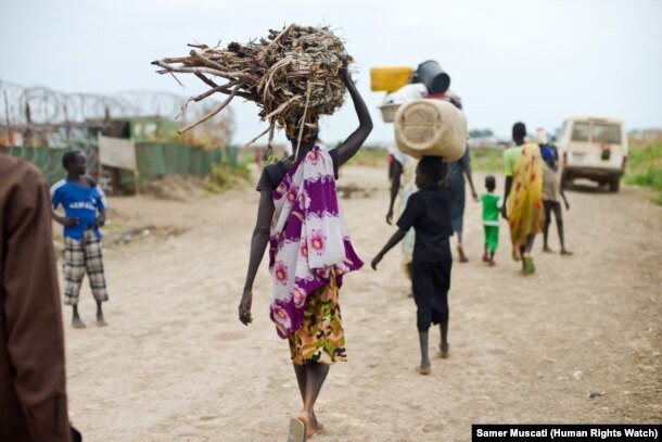 FILE - Women and children venture outside the UNMISS camp near Bentiu, in South Sudan, to collect firewood and charcoal.