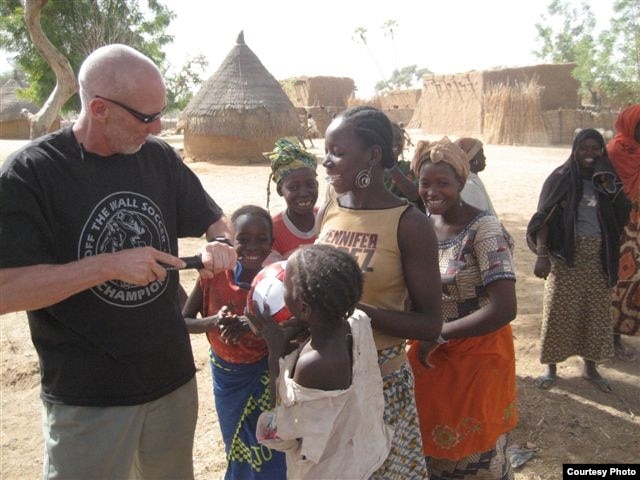 Dave Stahl helps children pump their soccer balls in Niger. (Courtesy Project Play Africa)