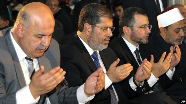 Egyptian Vice President, Mahmoud Mekki, left, President Mohammed Morsi, second left, Prime Minister Hesham Kandil, third left, and the Grand Sheik of Al-Azhar, Ahmed el-Tayeb, right, attend Eid al-Fitr prayers to mark the start of a three-day Muslim holiday that signals the end of the holy month of Ramadan, Aug. 19, 2012. 