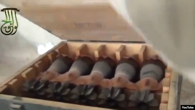 In this screen grab from a video posted to You Tube by Syrian activists, rebels who claim to have captured a government arm depot show crates rockets and other arms. 
