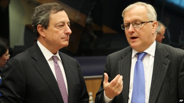 President of the European Central Bank Mario Draghi, left, listens to European Commissioner for Economic and Monetary Affairs Olli Rehn, during the Eurogroup meeting, in Luxembourg, October 8, 2012.