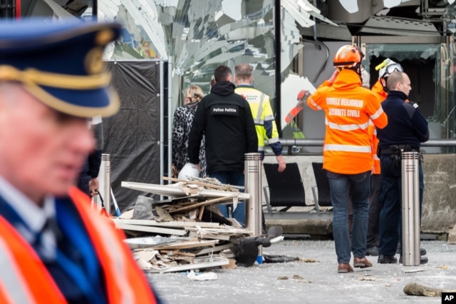 Police and other emergency workers stand in front of the damaged Zaventem Airport terminal in Brussels on March 23, 2016.