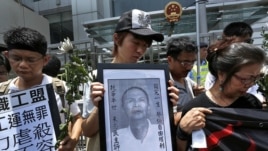 Protesters mourn the death of Chinese labor activist Li Wangyang, seen in picture at center, during a protest outside the Chinese central government's liaison office, in Hong Kong  June 7, 2012. 
