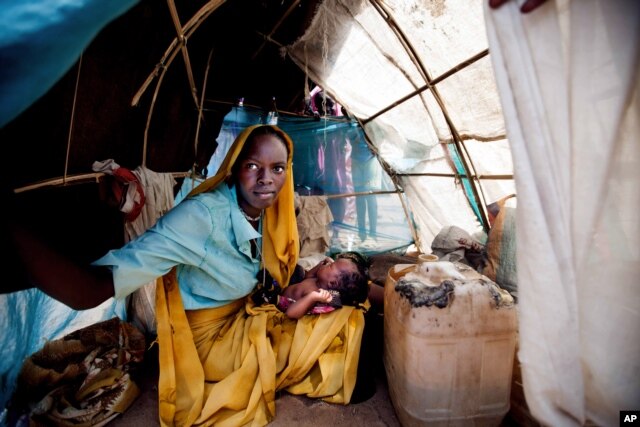 Một người phụ nữ và một em bé trong chiếc lều trú ẩn tạm thời ở trại tỵ nạn Kalma, Darfur, Sudan