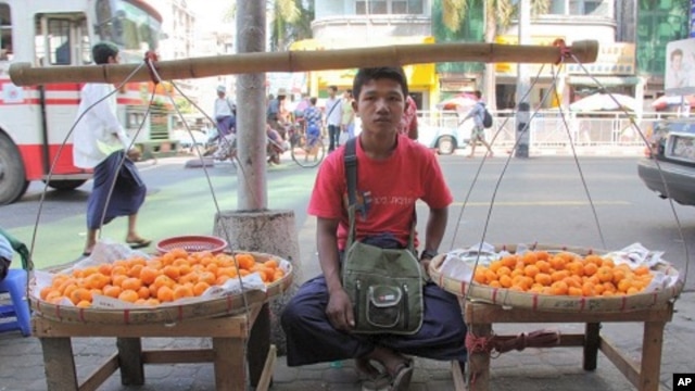 Boy sells fruit on sidewalk in Rangoon, Burma, December 5, 2011
