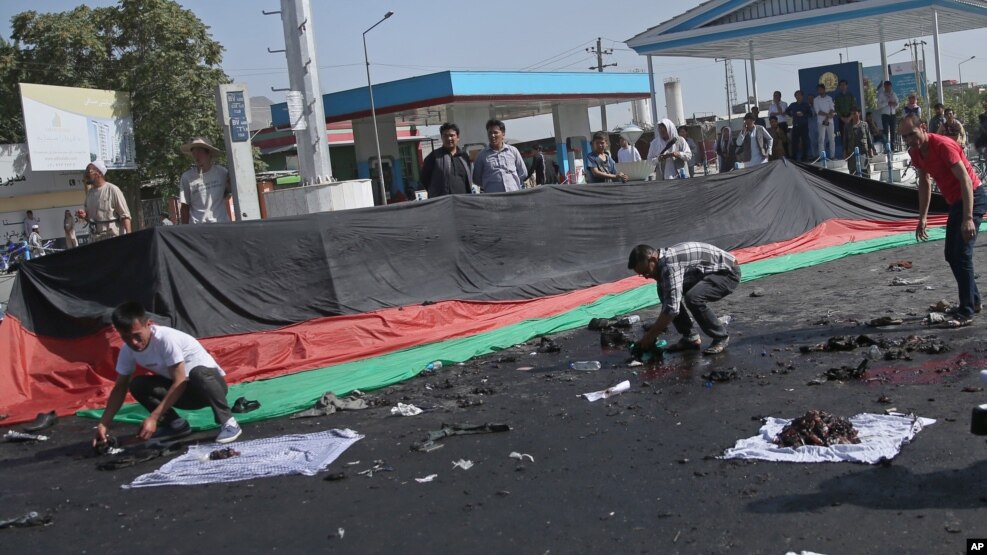 Những người Afghanistan thu lượm những gì còn xót lại sau một đánh bom chết người xảy ra tại một cuộc biểu tình của sắc dân Hazaras, ở Kabul, Afghanistan, thứ bảy ngày 23 tháng 7 năm 2016.