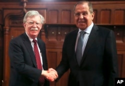 El asesor de seguridad nacional de EE.UU., John Bolton (izq.) y el canciller ruso Sergey Lavrov, saludan antes de iniciar conversaciones en Moscú, el lunes 22 de octubre de 2018.