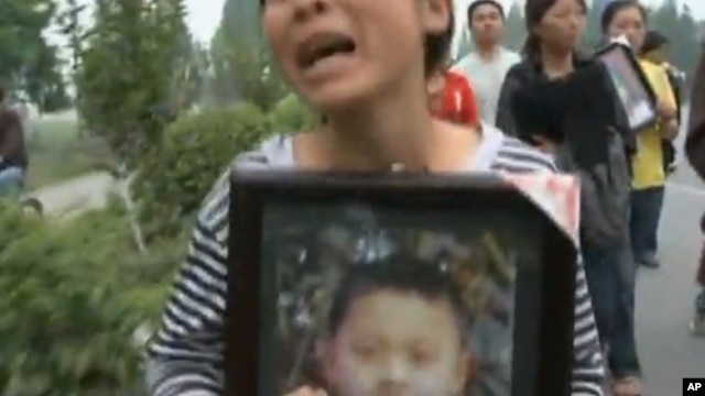 一位母亲手捧丧身汶川地震的儿子的照片（2008年资料照片）