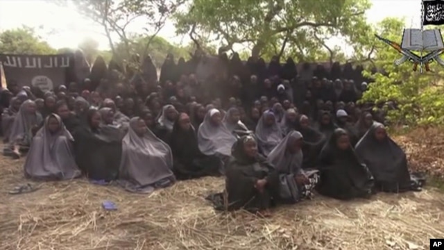 FILE - In this  photo taken from video  by Nigeria's Boko Haram terrorist network, Monday May 12, 2014 shows the alleged missing girls abducted from the northeastern town of Chibok. The new video purports to show dozens of abducted schoolgirls, covered in jihab  and praying in Arabic. 