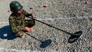 FILE - An Afghan soldier uses a mine detector during a demining drill at Camp Shaheen, a training facility for the Afghan National Army (ANA), west of Mazar-i-Sharif, Dec. 13, 2014.  