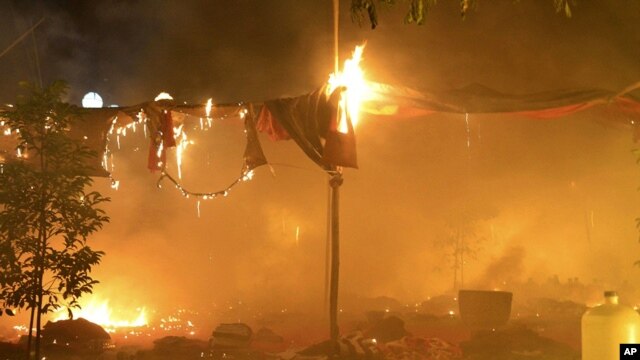 In this photo released by Eleven Media Group, an encampment occupied by protesters burns at the Letpadaung mine following a crackdown by security forces, near the town of Monywa, early Thursday morning, November 29, 2012.
