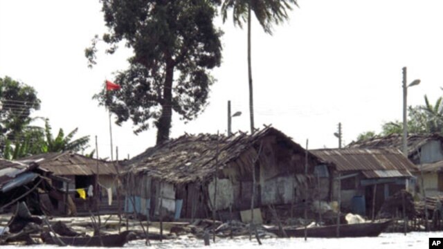 Shacks and houses line the shores of a river in Nigeria's Delta region