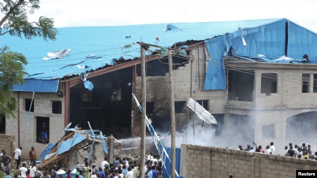 Onlookers gather near the bomb-damaged Shalom Church in the northern Nigerian city of Kaduna, June 17, 2012. 
