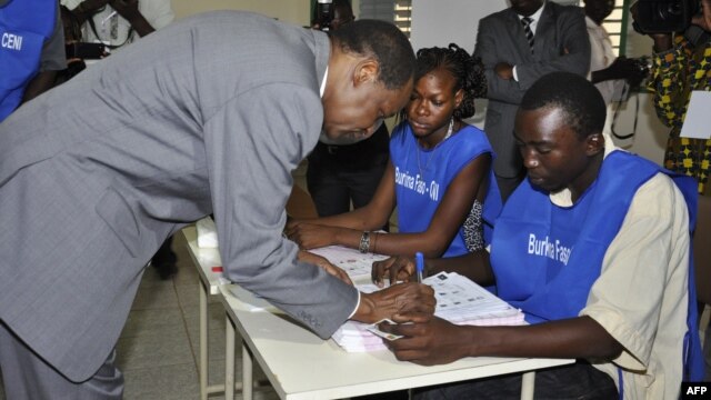 Burkina Faso incumbent President Blaise Compaore signs a document after casting his ballot at a polling station during legislative and municipal elections, in Ouagadougou, December 2, 2012.