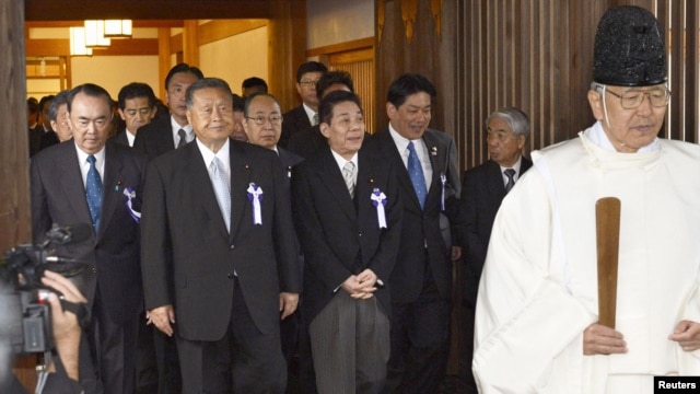 Japanese lawmakers, including cabinet ministers, are led by a Shinto priest as they visit the Yasukuni Shrine for the war dead in Tokyo, October 18, 2012.