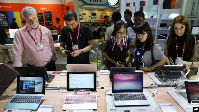 Visitantes a la exhibición Computex en Taiwán revisan los nuevos productos computarizados de ASUS