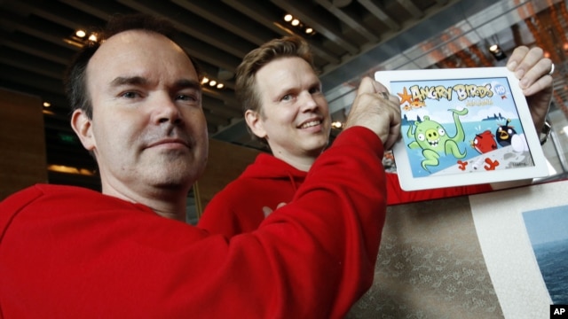 Peter Vesterbacka, direktur pemasaran perusahaan Mighty Eagle (kiri) dan Henri Holm, wakil presiden senior Rovio Asia, menunjukkan versi terbaru permainan Angry Birds pada pembukaan kantor cabang Rovio, yang memproduksi permainan tersebut, di Shanghai. (AP/Eugene Hoshiko)