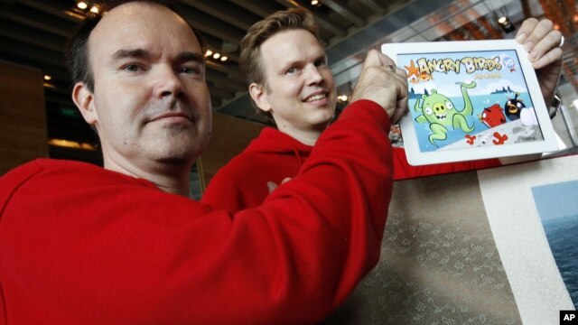 Peter Vesterbacka, Mighty Eagle, Chief Marketing Officer, left, and Henri Holm, Senior Vice President Of Rovio Asia, right, show the latest version of Angry Birds after the opening ceremony of the Shanghai office of Rovio, maker of popular computer game.