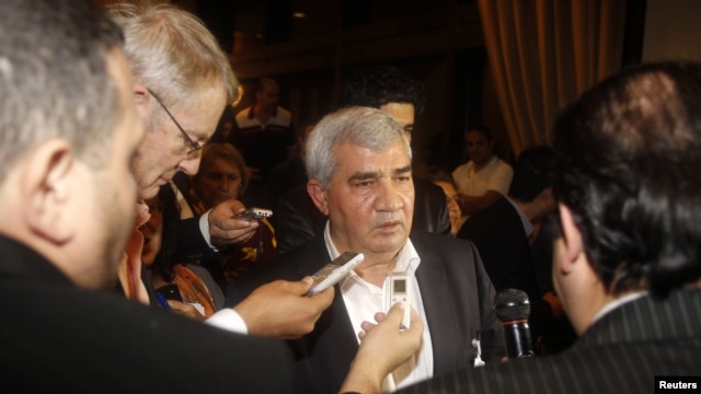Leading Syrian dissident Riad Seif (C) speaks to the media at the meeting of the General Assembly of the Syrian National Council in Doha, November 8, 2012. 