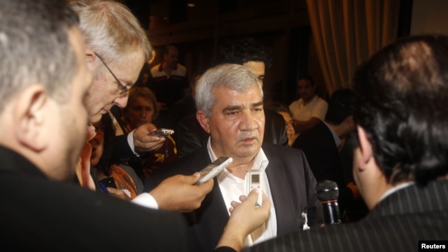 Ông Riad Seif (giữa) nhân vật bất đồng chính kiến hàng đầu của Syria, nói chuyện với các nhà báo tại cuộc họp ở Doha 