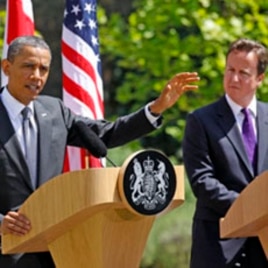 British Prime Minister David Cameron (R) watches U.S. President Barack Obama speak to reporters at Lancaster House in London May 25, 2011