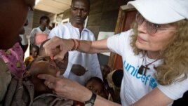UNICEF Goodwill Ambassador Mia Farrow gives a child a dose of vitamin A, to help boost immunity, during a UNICEF-sponsored immunization at the Majengo health center in Goma, capital of North Kivu Province.