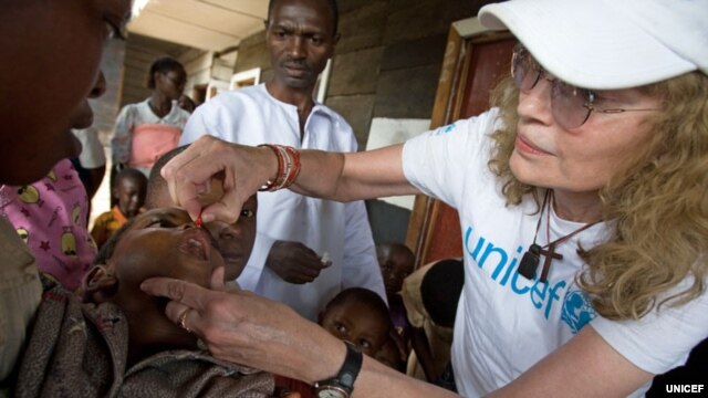 UNICEF Goodwill Ambassador Mia Farrow gives a child a dose of vitamin A, to help boost immunity, during a UNICEF-sponsored immunization at the Majengo health center in Goma, capital of North Kivu Province.