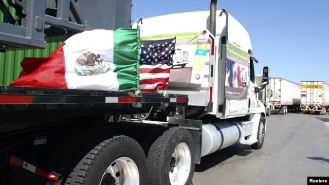 Camiones mexicanos con las banderas de México y Estados Unidos, en la frontera de Laredo.