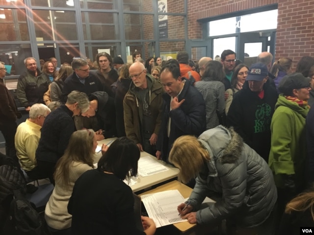 Caucus-goers register at Hanawalt Elementary School, Des Moines, Iowa, Feb. 1, 2016. (M. Cagler/VOA)