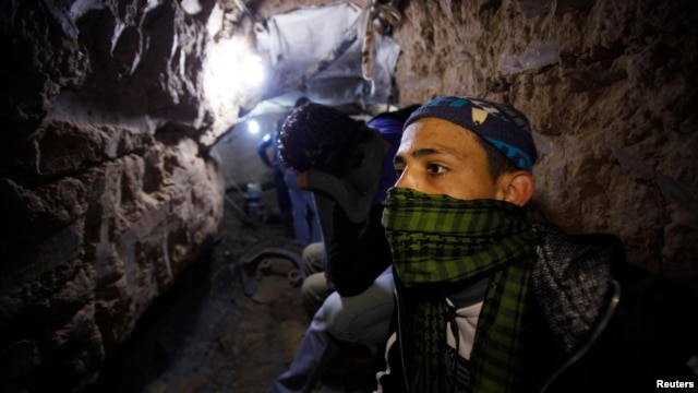 Palestinian worker moves goods through a smuggling tunnel between the Gaza Strip and the Egyptian Sinai February 19, 2013. 
