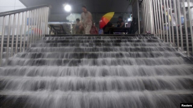 Nước lũ tràn xuống cầu thang ga xe điện ngầm ở Bắc Kinh, ngày 21/7/2012
