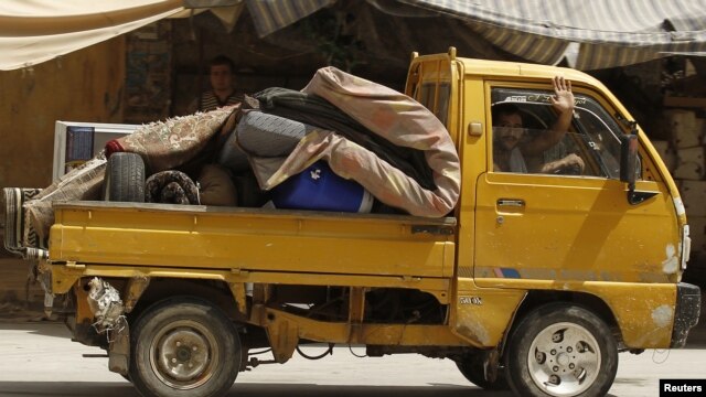 A man waves as he flees Aleppo, July 29, 2012. 