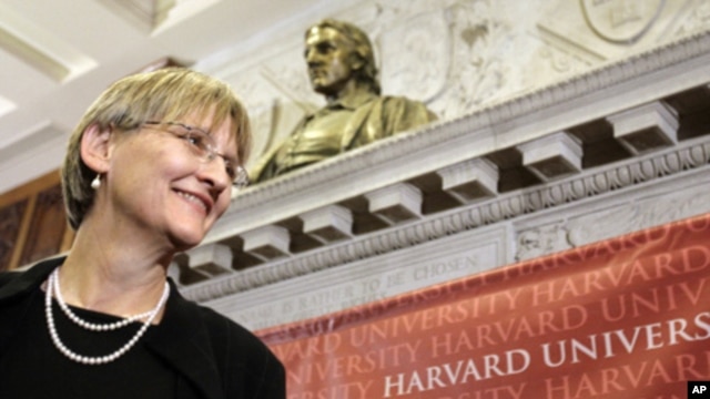 Harvard University President Drew Gilpin Faust stands beneath a bust of the founder of the university, John Harvard