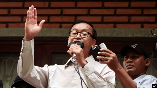 President of National Rescue Party Sam Rainsy, center, gives a speech during a public forum at their party's office in Phnom Penh, Cambodia, July 31, 2013. 