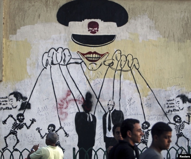 This graffiti near Cairo's Tahrir Square depicts the ruling military council as controlling the presidential elections. (Reuters)