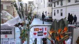 Hoa gắn trên hàng rào an ninh bên ngoài tòa soạn Charlie Hebdo ở Paris, Pháp sau khi xảy ra vụ tấn công, 14/1/15