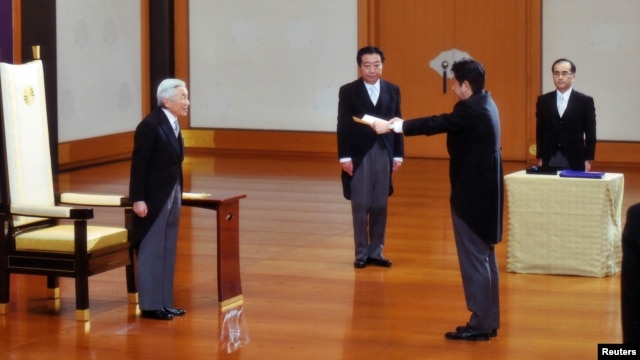 PM baru Jeoang, Shinzo Abe (dua dari kanan) menerima sebuah sertifikat dari Kaisar Akihito (kiri), diawasi oleh mantan PM Yoshihiko Noda (dua dari kiri) dalam upacara pelantikan PM Jepang di Istana Kekaisaran Jepang di Tokyo (26/12).