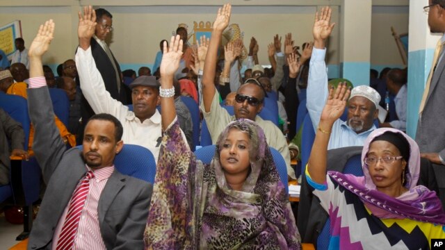 FILE - Somalia lawmakers raise their hands during a confidence vote on Prime Minister Abdiweli Sheikh Ahmed, at the Parliament Building in Mogadishu, Somalia.